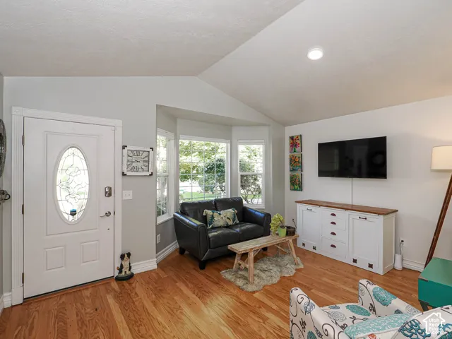 Vaulted ceiling, recessed lighting, hardwood flooring, bay window, built-in media console