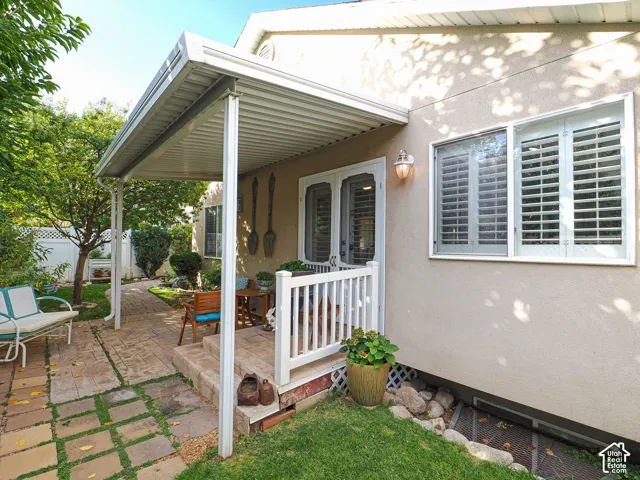 Covered patio area with white railing and outdoor wall light