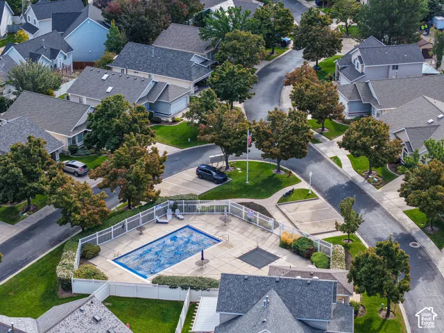 Community with an outdoor swimming pool, paved roads, streetlights, and mature trees