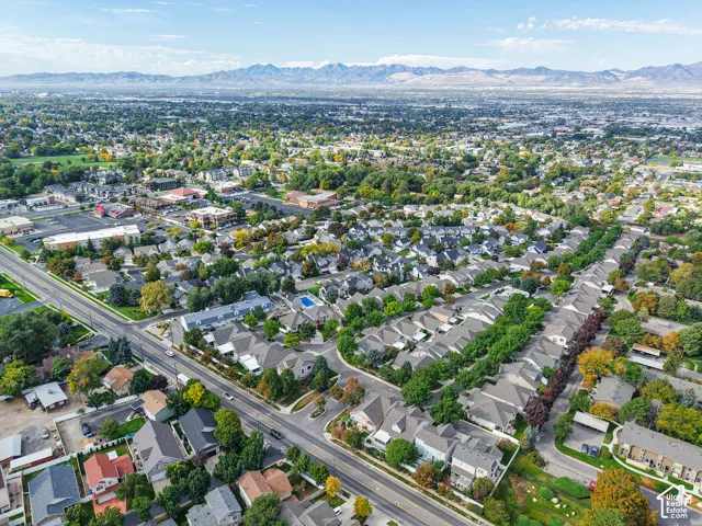 Expansive residential area with a prominent mountain backdrop, featuring a mix of single-family homes and townhomes, and a clear road network