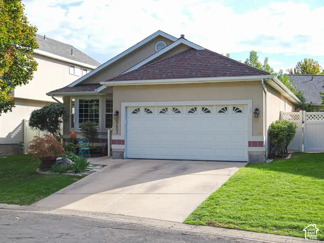 Stucco exterior with a tiled roof, bay window, and an attached two-car garage