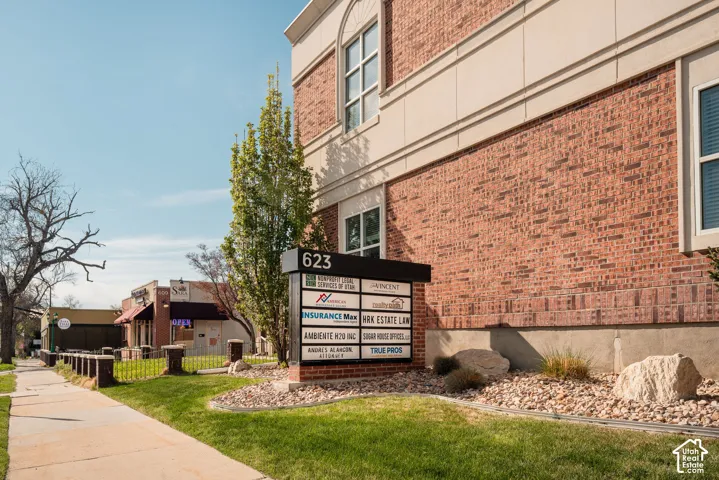 Brick exterior with a stone foundation, featuring a prominent business directory sign