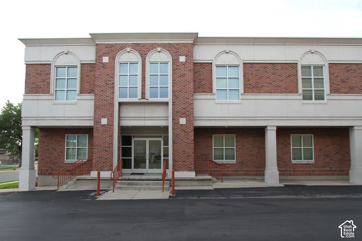 Brick exterior with stone accents, arched windows, and a central double-door entry