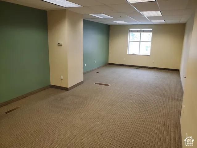 Carpeted flooring, recessed lighting, neutral painted walls, accent wall, and a large window