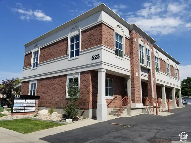 Brick exterior with white trim, arched windows, prominent signage, and an asphalt parking area