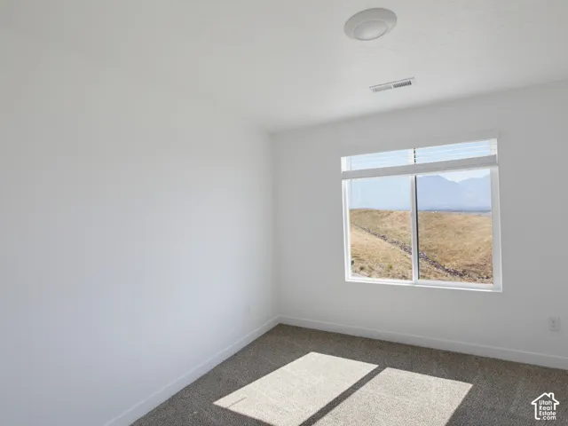 Recessed ceiling light fixture, white walls, wall-to-wall carpet, and window with expansive scenery