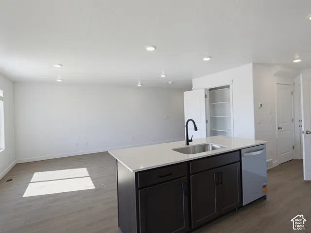 Kitchen island with stainless steel sink, black faucet, and white countertop