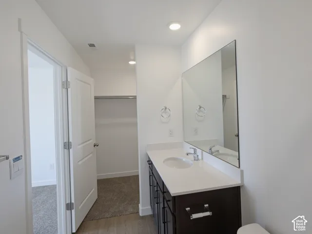 Contemporary vanity with a white countertop and integrated sink, chrome faucet, and a large wall-mounted mirror