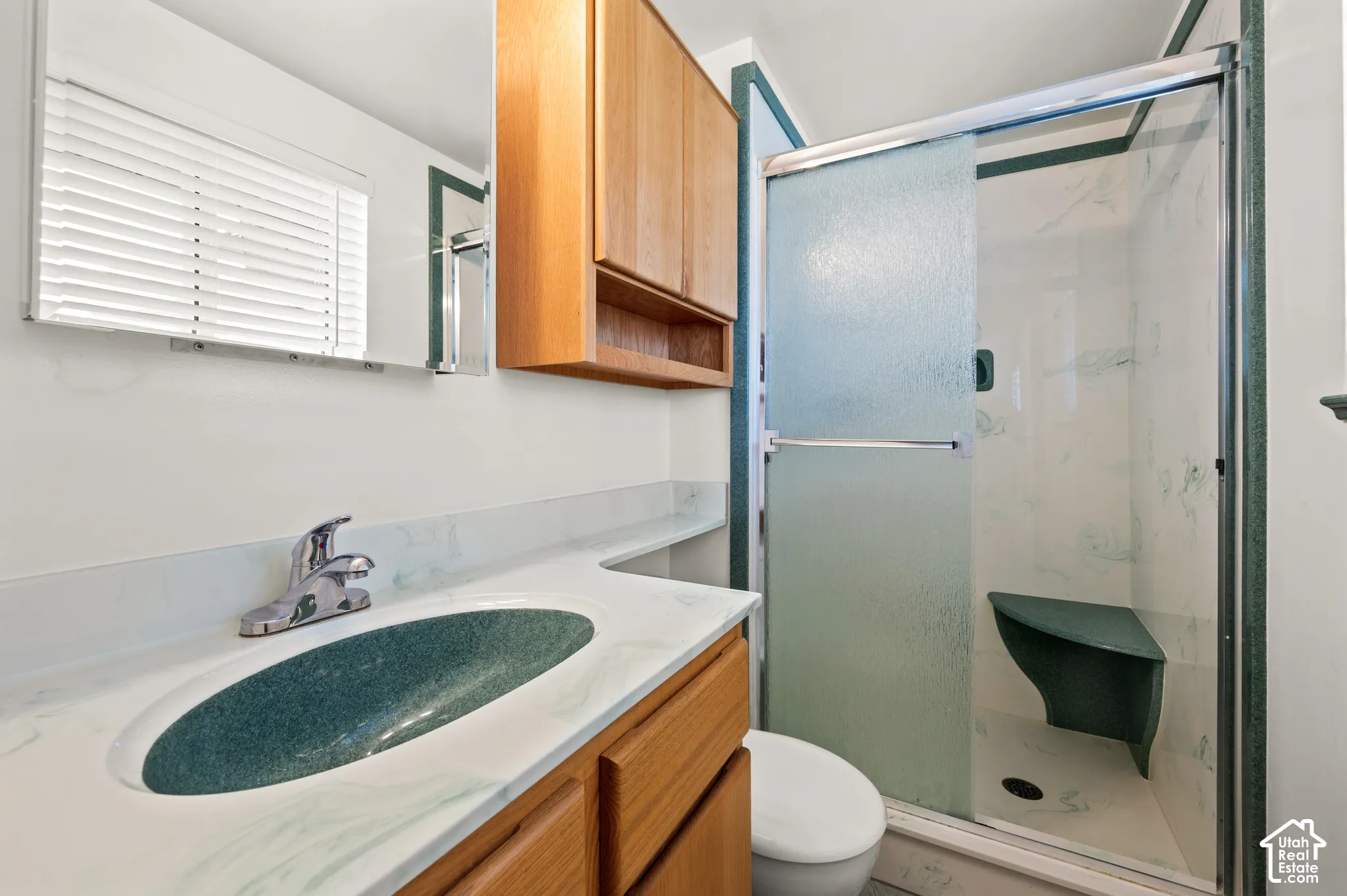 Vanity with integrated sink, wood-finish cabinetry, and mirrored medicine cabinet