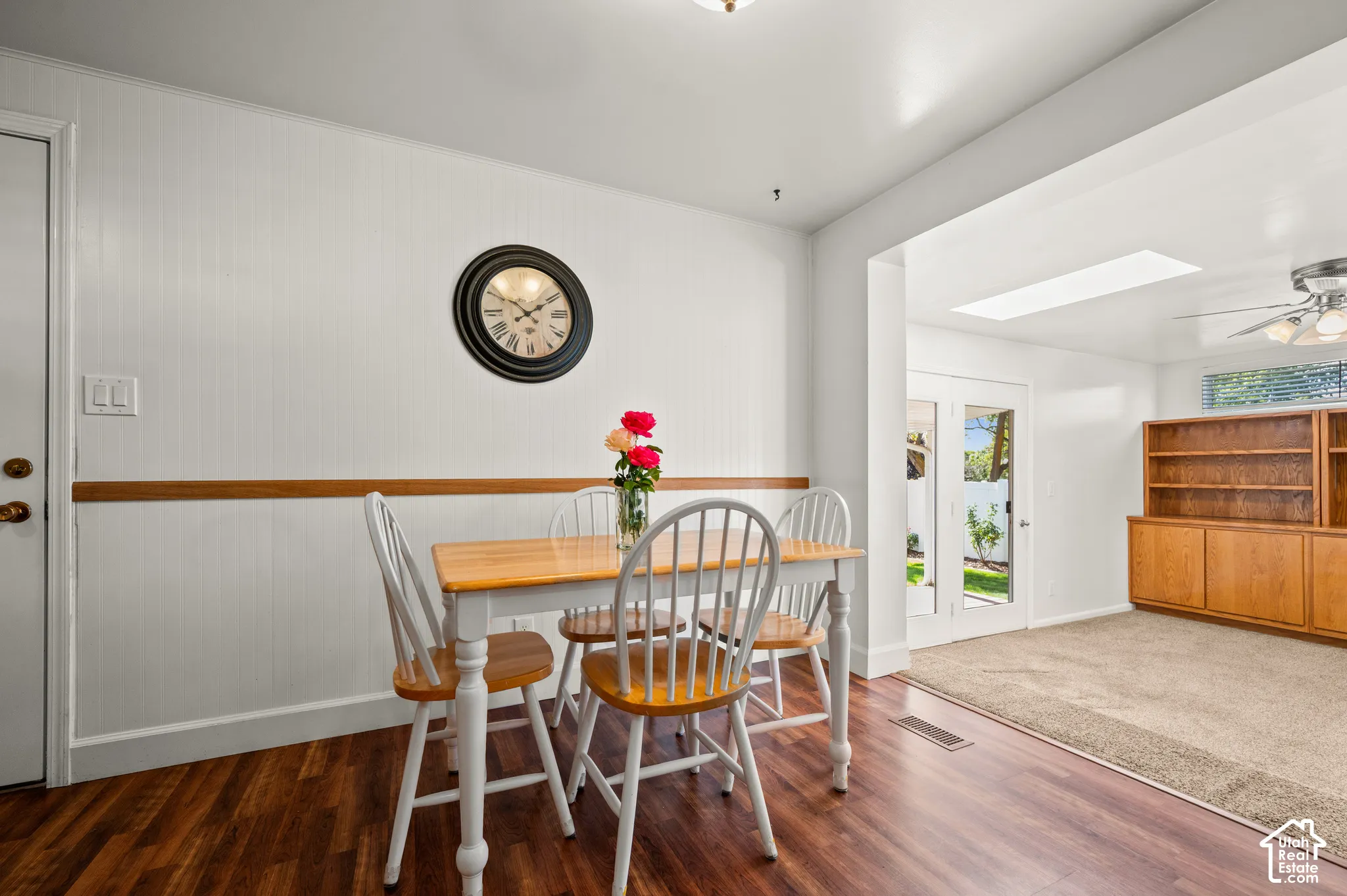 Wood-finish flooring with a white paneled wall