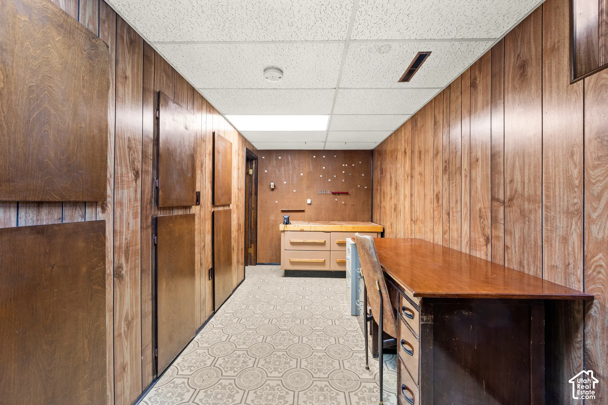 Wood paneling throughout, built-in cabinetry, patterned flooring, and recessed lighting