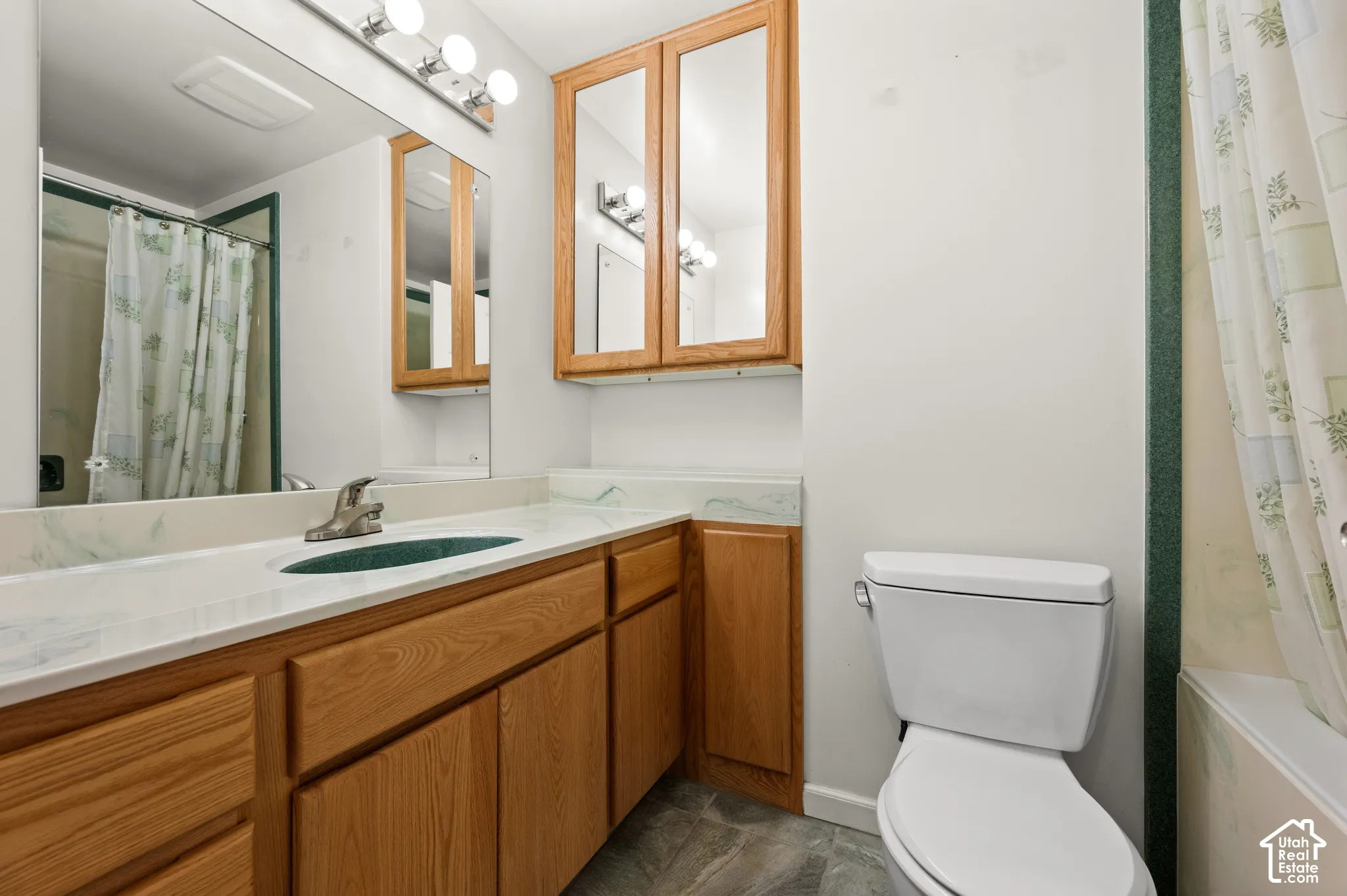 Wood-finish vanity with an integrated countertop, undermount sink, and wall-mounted mirror