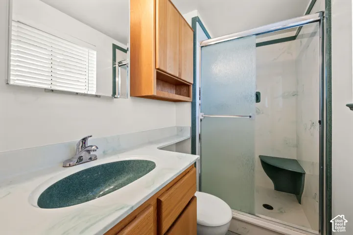 Vanity with integrated sink, wood-finish cabinetry, and mirrored medicine cabinet