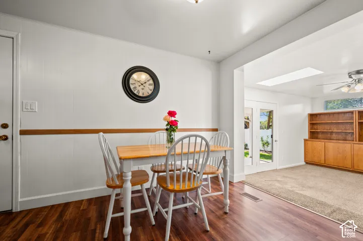 Wood-finish flooring with a white paneled wall