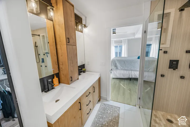Dual vanity with white countertops, wood-finish cabinetry, and matte black fixtures