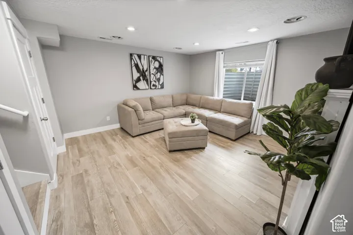 Light wood-finish flooring, recessed lighting, and a white interior door