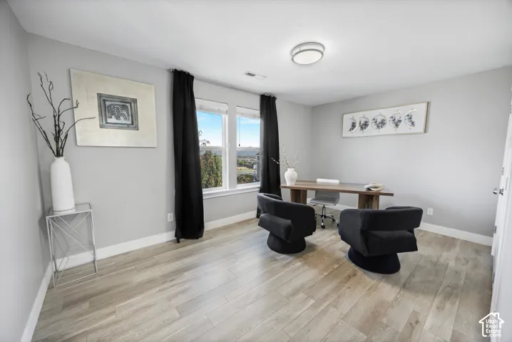 Light wood-finish flooring, recessed lighting, expansive windows, and a neutral wall palette