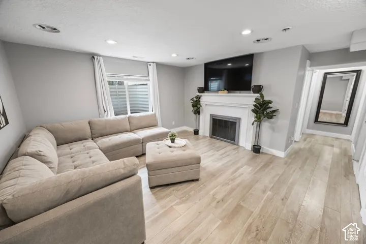 Recessed lighting illuminates wood-finish flooring