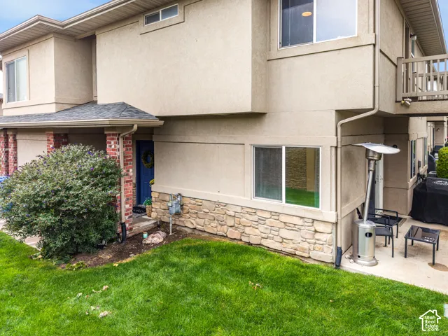 Stucco exterior with stone veneer accents and a covered entry
