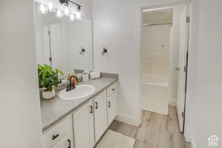 White vanity with integrated sink, speckled countertop, and dark-finished faucet