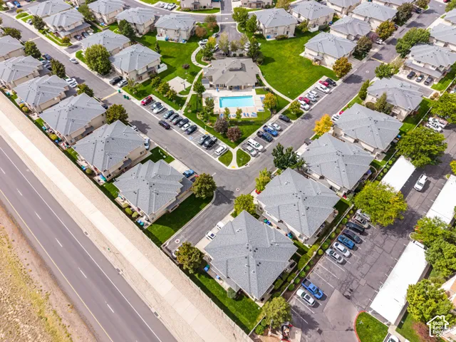 Community featuring multiple residential structures, manicured green spaces, paved roadways, and dedicated parking areas