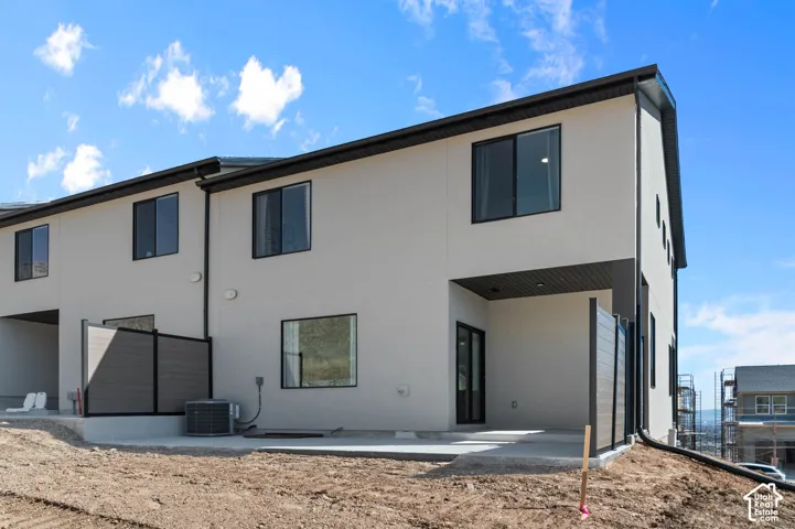 Smooth stucco exterior with black trim windows, private patio area, and covered outdoor space
