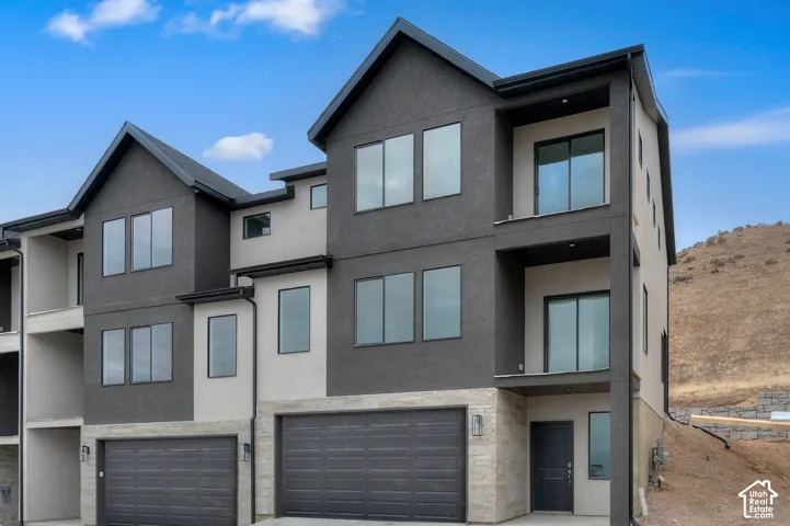 Multi-level exterior with a mix of dark gray and light stucco finishes