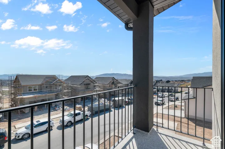 Balcony with black metal railings, a textured grey support column, and a concrete floor