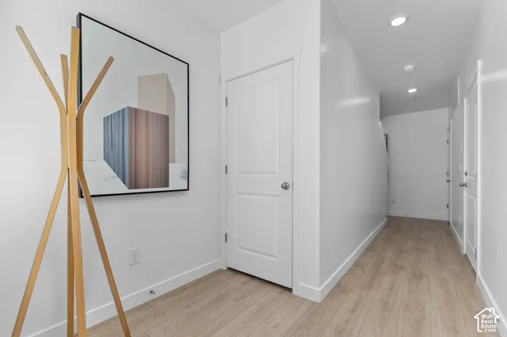Entryway featuring wood-finish flooring, recessed lighting, and white paneled doors