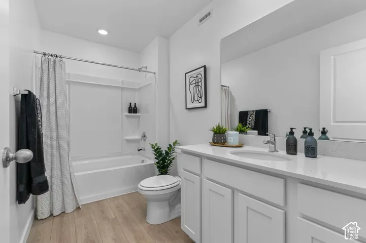White vanity with shaker-style cabinetry, an integrated sink, and a large wall-mounted mirror