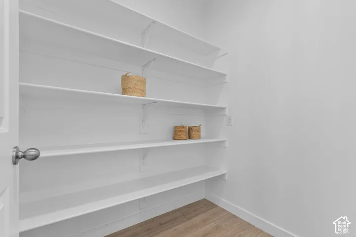 Built-in white shelving, wood-finish flooring, and crisp white walls