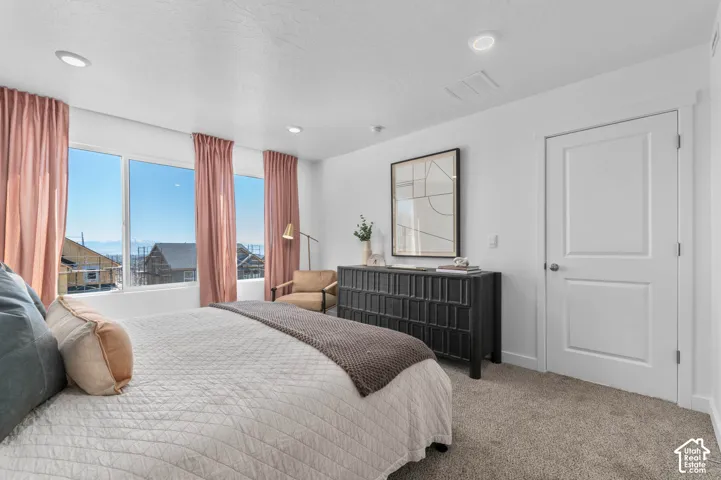Recessed lighting, light-colored walls, carpeted flooring, and a multi-pane window