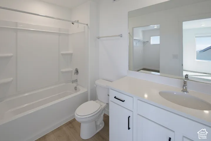 White vanity with dual lower cabinetry, white countertop, undermount sink, and chrome faucet