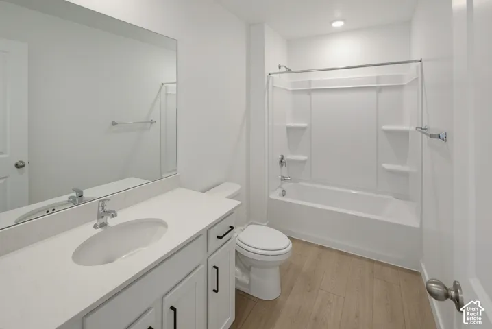 White vanity with a single basin sink, white countertop, and chrome faucet
