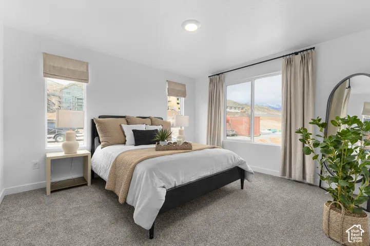 Recessed lighting, large window with expansive mountain scenery, and light gray carpeting