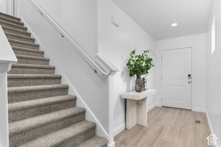 Carpeted staircase with white handrails and risers