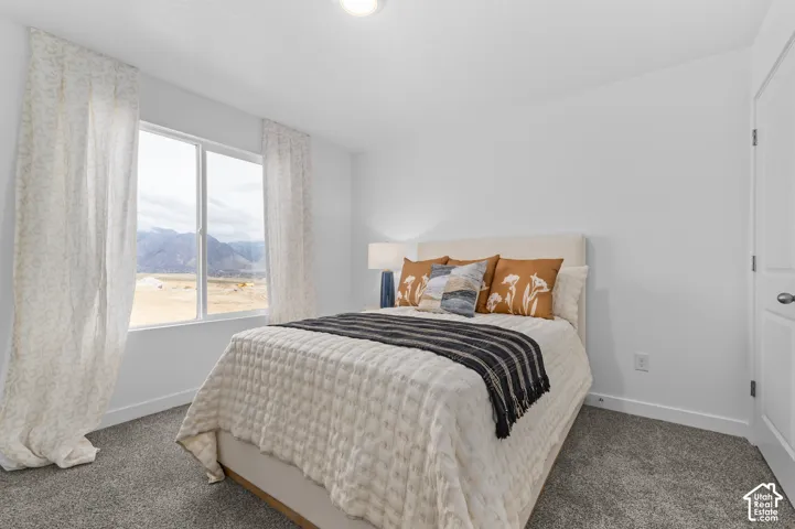 Expansive window with mountain backdrop, recessed ceiling lighting, textured carpet flooring, and a white paneled door