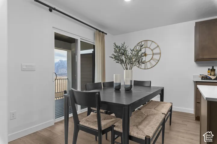 Sliding glass door leading to a patio, wood-finish flooring, recessed lighting, and wall-mounted cabinetry