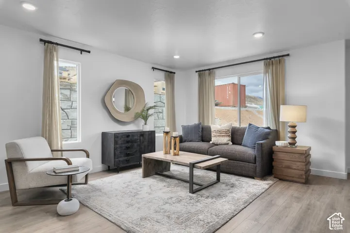 Recessed lighting, light wood-finish flooring, white walls, large window, and secondary vertical windows