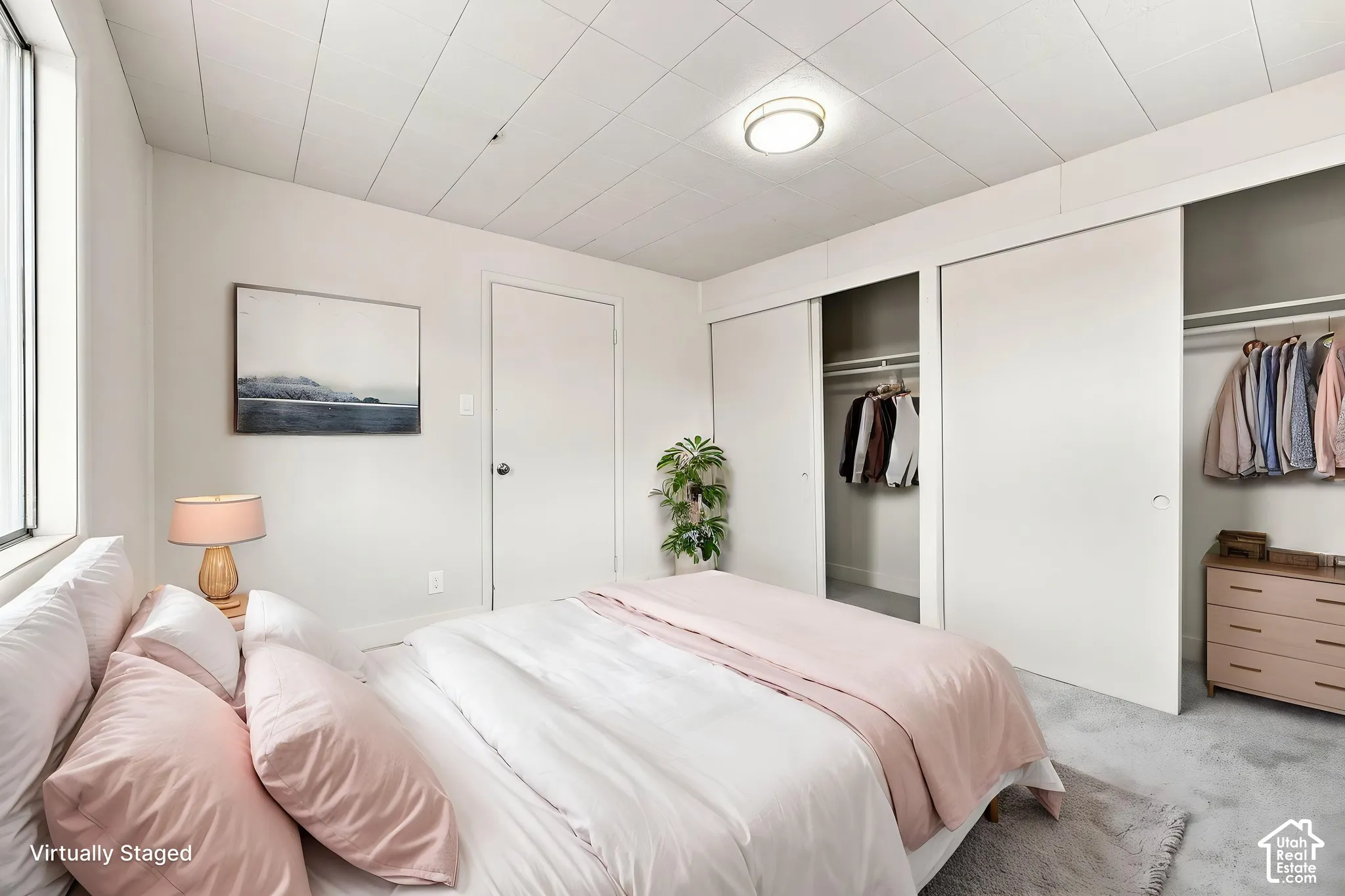 Neutral interior featuring a panel ceiling, plush carpeting, a flush-mount light fixture, and dual sliding-door closets
