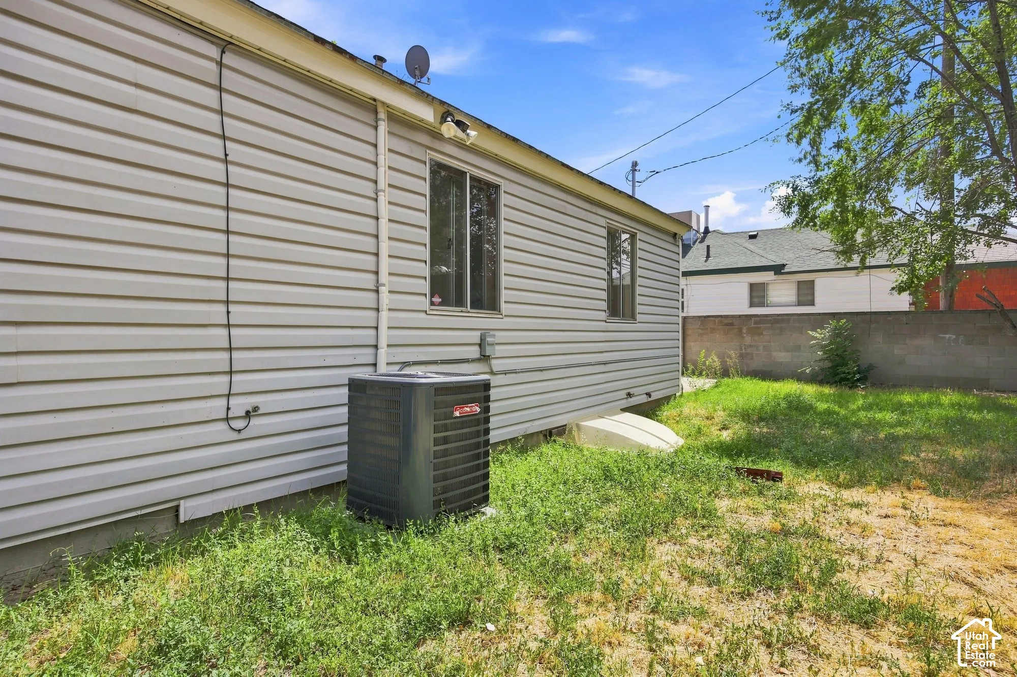 Vinyl siding exterior with a side yard and a concrete block perimeter wall