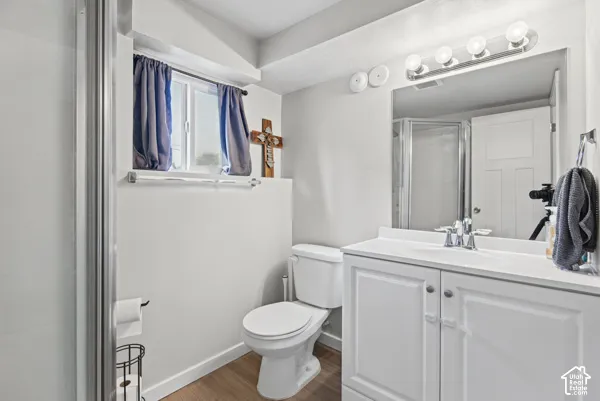 White vanity with a solid surface countertop, chrome faucet, and integrated mirror with overhead lighting