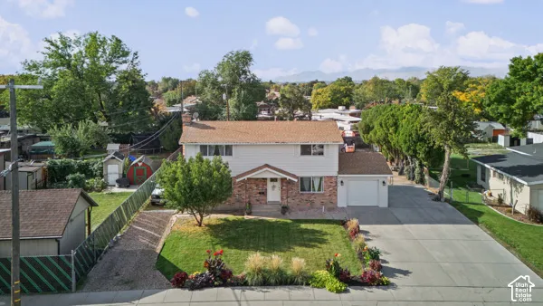 Two-story residence with brick and siding exterior, attached garage, and paved driveway