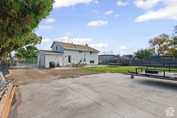 Expansive concrete patio with direct access to the interior, complemented by a manicured lawn area