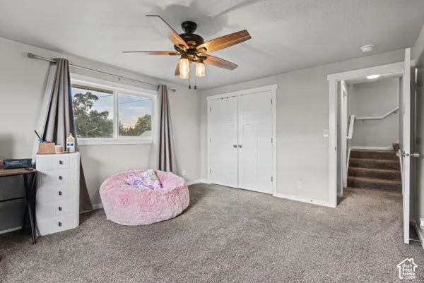 Wall-to-wall carpeting and a ceiling fan with light fixture