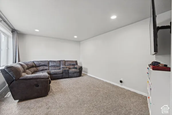 Recessed ceiling lighting, light gray wall paint, white trim, and light-colored carpeting