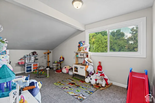 Carpeted room with a pitched ceiling and a horizontal window