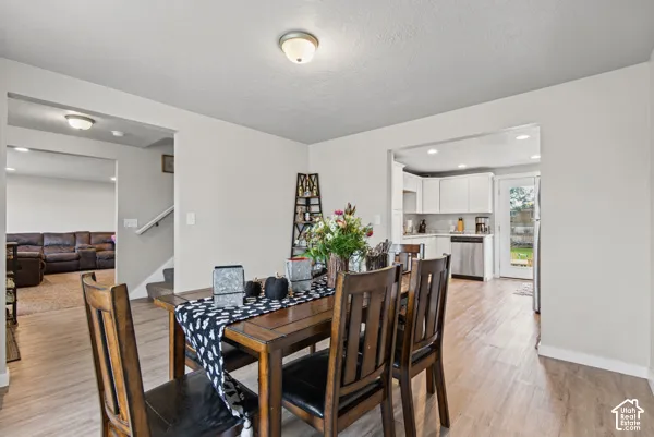 Wood-finish flooring throughout, white walls, and recessed lighting