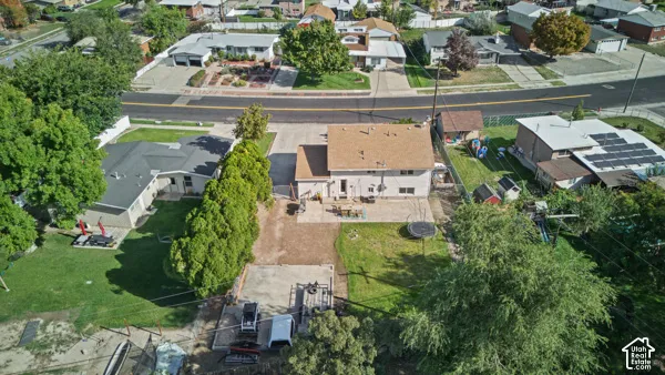 Expansive property featuring a brown shingle roof, a paved driveway, and a spacious backyard with established trees
