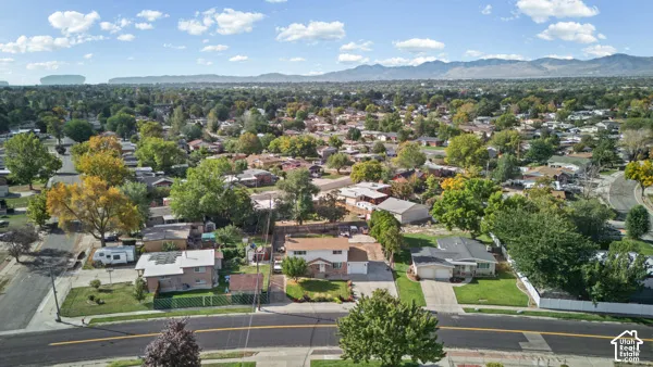 Expansive neighborhood setting with mature trees and mountain backdrop